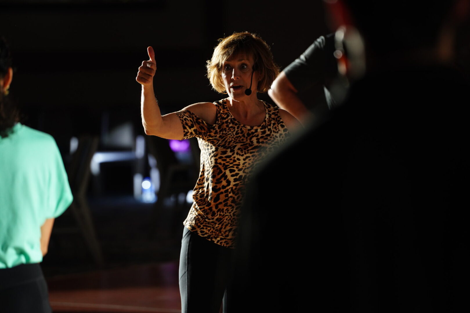 A woman in leopard print shirt holding up two fingers.