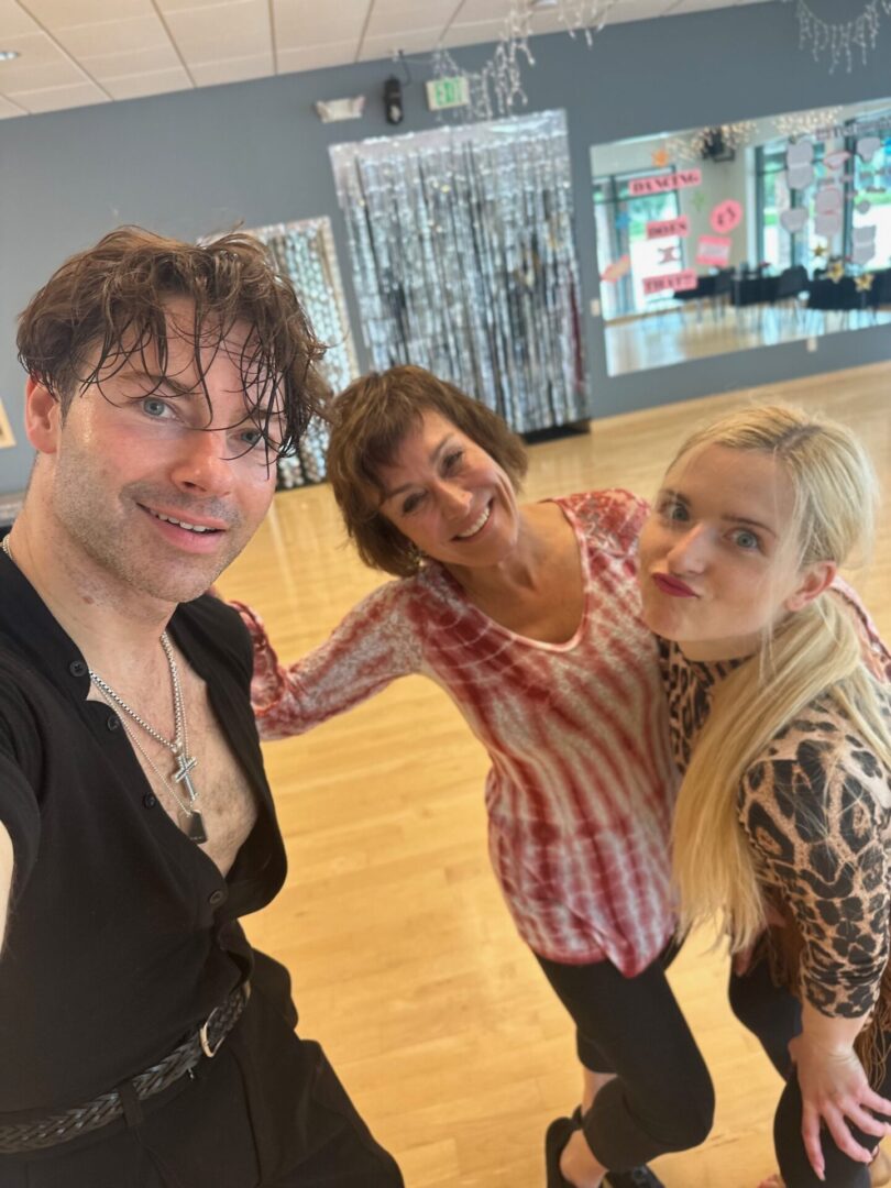 Three people pose for a picture in the dance studio.