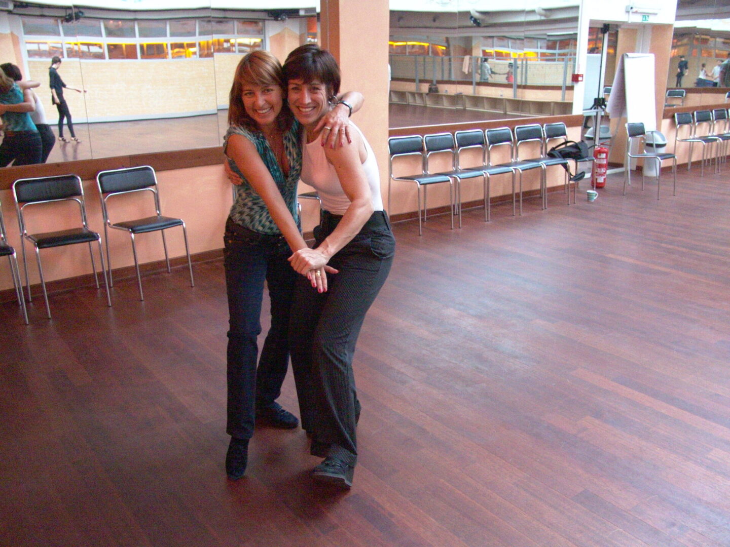 Two women pose for a picture in the dance floor.